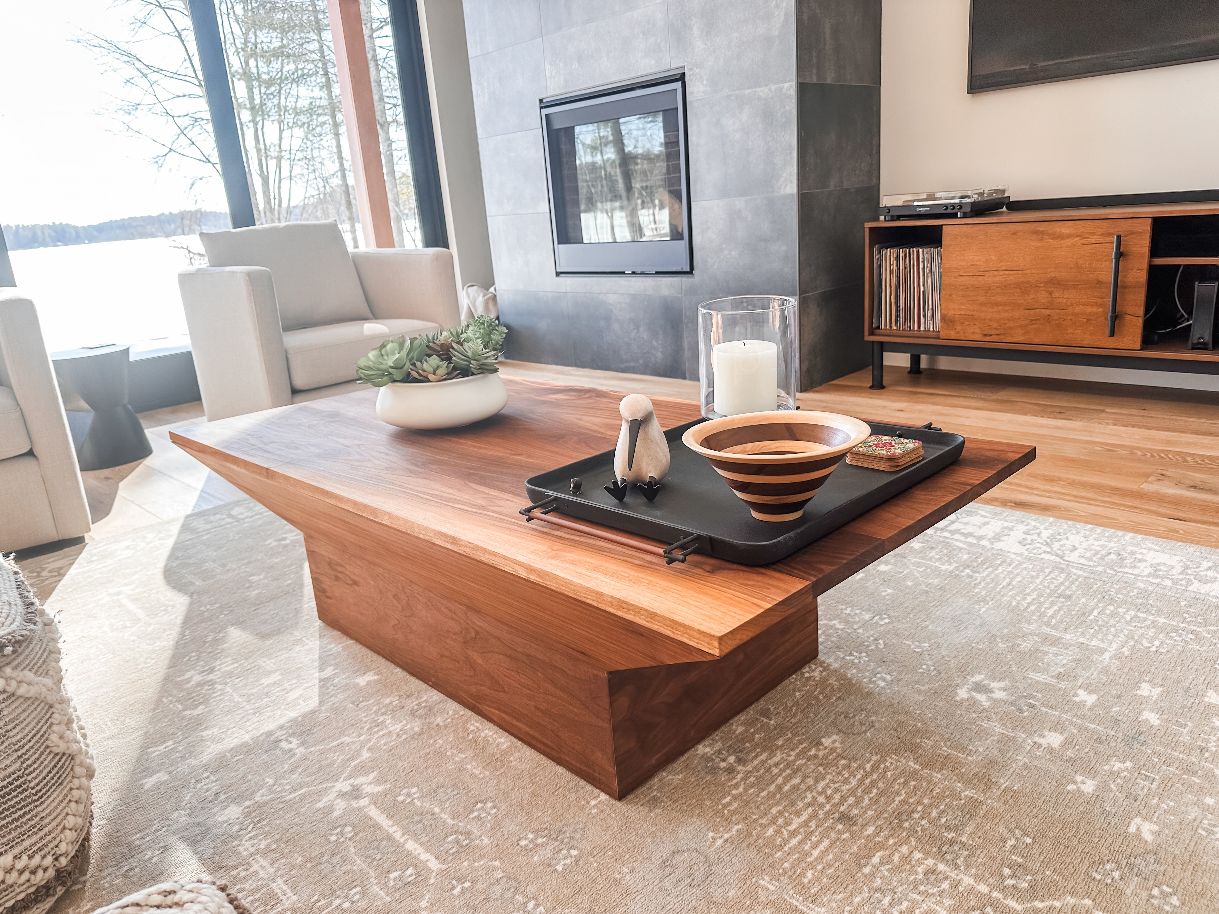 A broad, low walnut coffee table in a bright living room